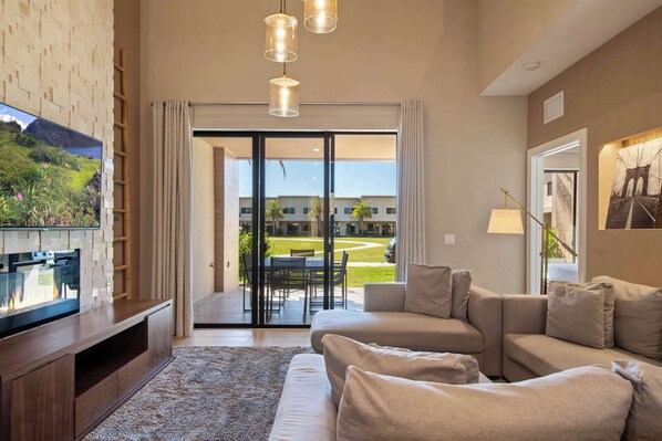 Modern retreat with cozy seating, stylish decor, and patio views of green lawns.
