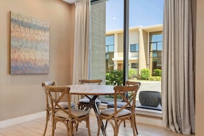 Cozy dining nook with natural light, modern art, and peaceful courtyard views