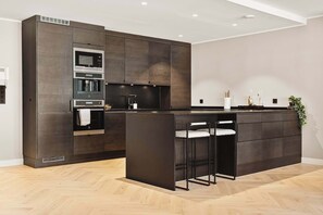 Dark, modern kitchen with a spacious island and ample counter space.