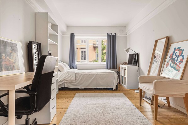 A well-organized room, showcasing a balance between work and personal areas.