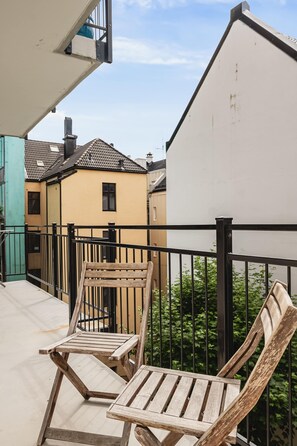 Urban balcony scene with a view of pastel-colored buildings.
