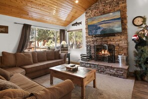 Gather around in our inviting living room, where rustic charm and modern comfort meet by a warm fireplace