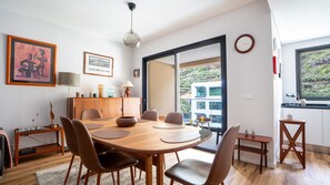 Brava Suite by LovelyStay features a charming dining area with a beautiful wooden table, perfect for shared meals. The warm ambiance and modern design create an inviting space to gather and enjoy. #cozy #spaciousapartment