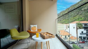 Brava Suite by LovelyStay is a cozy getaway in Ribeira Brava. Relax on the balcony with breathtaking mountain views. This well-located apartment offers modern amenities and private parking for a hassle-free stay. #balcony #seating #outdoorfurniture