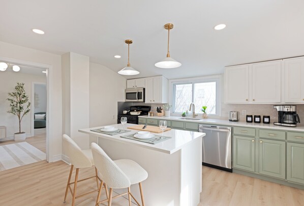 Newly renovated kitchen with quartz countertops and island with bar seating