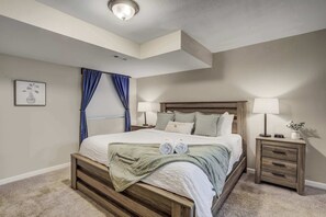 Retreat to the spacious master bedroom featuring a plush king-size bed, soft linens, warm lighting, and a tranquil atmosphere for restful nights.





