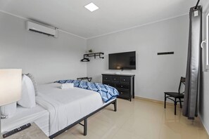 Stylish bedroom with a TV and workspace.

