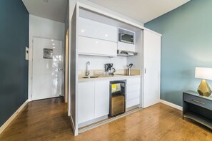 Small kitchen with mini fridge, coffee maker, micro wave and stove.