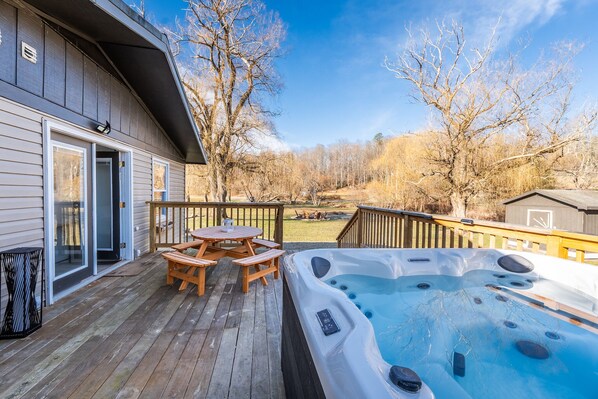 6 seater hot tub and 8 seater picnic table on outdoor deck
