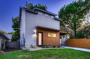 Inviting front entry with lush greenery and a well-maintained lawn.