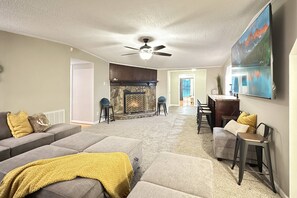 Large living space with ample seating for at least 20 guests - with fireplace and 82" TV