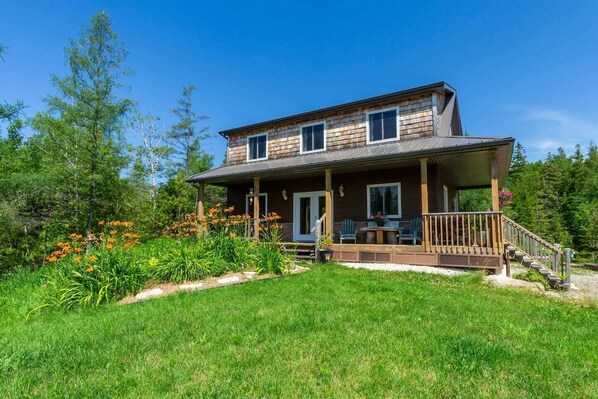 Spacious yard with wildflowers and sunshine—perfect for games, lounging, or soaking in cottage-country vibes.