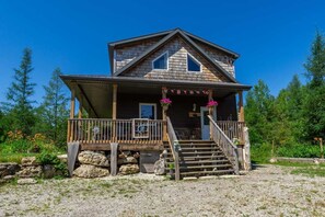Charming cottage entrance with rustic stone steps and a cozy porch—your peaceful Bruce Peninsula escape starts here.