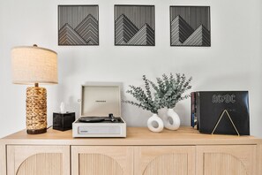 Add a touch of nostalgia to your stay with our Bluetooth-enabled record player, sitting atop a stylish console table. Whether you prefer vinyl or streaming, enjoy your favorite tunes in the heart of the home. Inside the console, you'll find a selection of board games—perfect for a fun night in with family and friends!