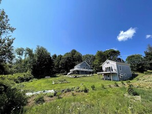 Ferry Cottage sits amid lush spring gardens, nestled in vibrant green surroundings.