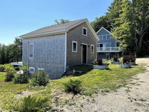 Charming Ferry House with cedar shake siding, vibrant planters, set in serene Lincolnville Beach.
