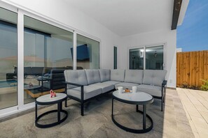 This patio is designed for poolside luxury, featuring comfortable and elegant seating that complements the stunning pool area.