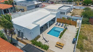 Luxury outdoor living, all in one space. Enjoy shaded and sunny dining, comfortable seating, a hammock, BBQ grill, and an outdoor shower by the pool.