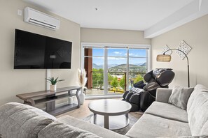 Living room with view of pool, lake and mountains.