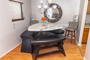 Dining area include large triangular bench with alternate bar stools.
