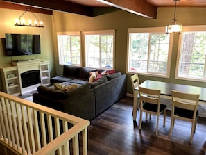 Upper Great Room: Roku TV, electric fireplace, sectional couch, dining area. Connects to lower level via stairs (left side of photo).