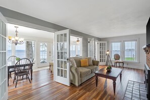 Relax and unwind in this bright living room with gorgeous views of the lake. The comfortable seating and large windows invite you to take in the tranquil waters, ideal for your next getaway.
