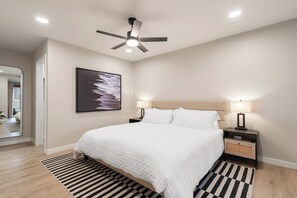 Spacious primary bedroom with cozy king bed and a sleeper sofa for one.