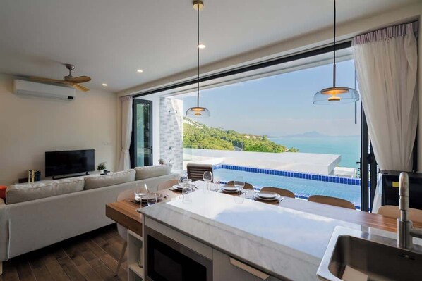 The living room features bi-fold windows that open completely, providing unobstructed views.