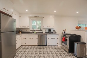 Kitchen gas stove, oven, dishwasher and refrigerator.