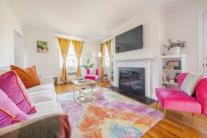 Living room on entry level with tv and view into the beautiful kitchen.