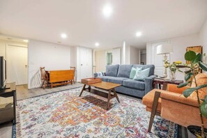 Furnished basement with tv and pull out sofa bed.