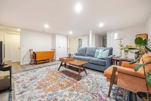 Furnished basement with tv and pull out sofa bed.