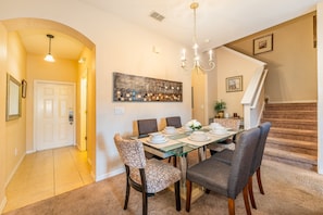 Dining room showing table seating for 6, entry way and the stair location for the second floor.