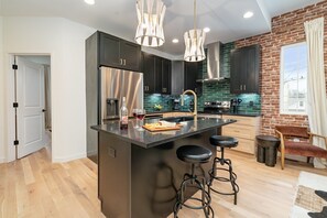 1st Unit - 2nd Floor: Fully equipped kitchen with stainless steel appliances and a kitchen island with seating for 2 guests.