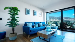 Spacious and modern living room with elegant décor, ample natural light, and seamless access to a large balcony with stunning views. Perfect for relaxation and entertaining. #mountainview #oceanview