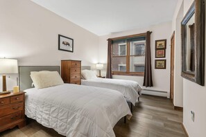 Bedroom 1: Two twin beds, dresser, closet, room-darkening shades