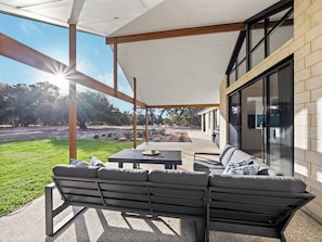 Relax beneath the verandah with sweeping views over the backyard and golf course.