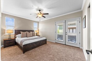 Rest easy in this spacious, sunlit bedroom with direct patio access and a luxurious bed. 
