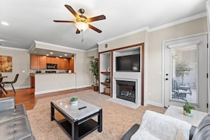 Open-concept living with fireplace, dining area, and bright kitchen - perfect for relaxing or entertaining.