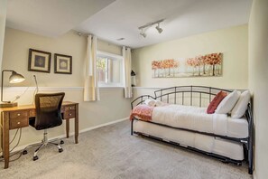 Bright and versatile bedroom with a cozy daybed, a pull-out trundle for extra sleeping space, and a dedicated workspace—ideal for work or relaxation.




