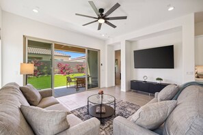Living Room has Access to Back Yard with Large TV