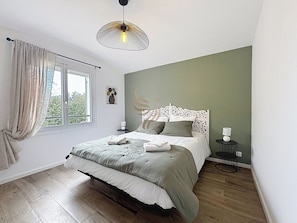 Chambre lumineuse et sereine. Le lit double offre un confort exceptionnel, idéal pour vous reposer après une journée d'exploration. Ambiance chaleureuse et décoration moderne pour un séjour paisible.