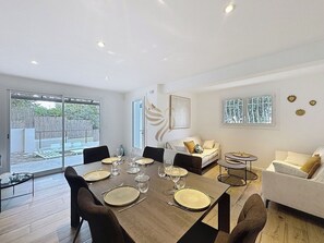 L'espace salon-salle à manger baigne de lumière naturelle, avec une exposition idéale pour une soirée conviviale. Les canapés offrent un coin détente parfait pour discuter après un bon repas.