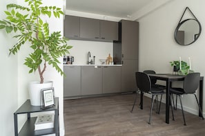 Relax in this airy, light-filled living space featuring a comfy sofa, smart decor, and a cozy dining spot.