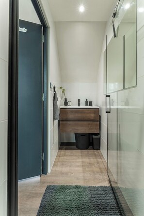 Modern bathroom with a walk-in shower, fresh towels, and stylish finishes — everything you need to refresh and relax.