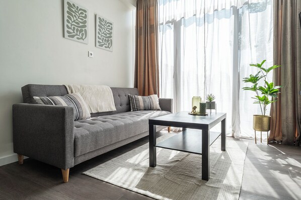 A stylish living space with a comfy sofa, perfect for lazy mornings or cozy evenings.