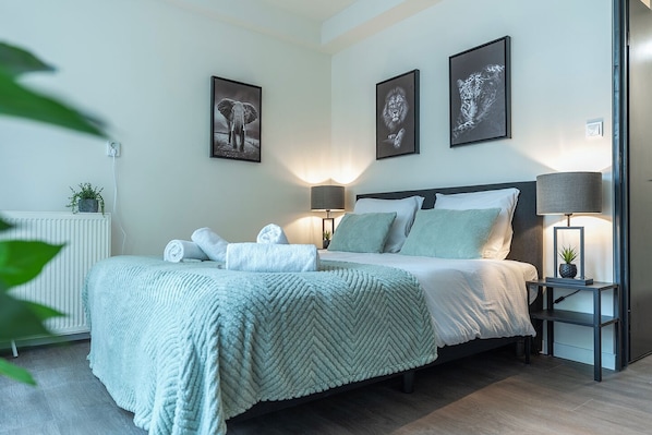 Enjoy a comfortable night in this modern room with fresh details, cozy lighting, and a warm, inviting atmosphere.