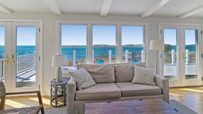 Sun room with comfortable seating and panoramic views of the water