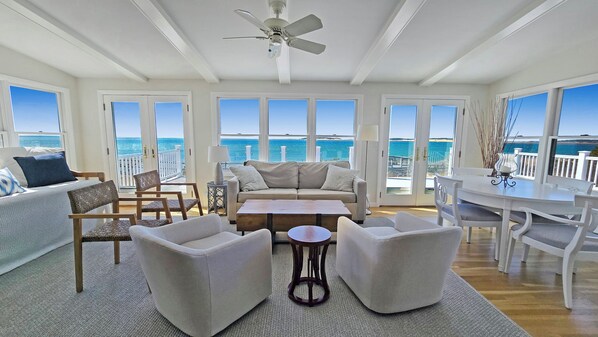 Sun room with comfortable seating and panoramic views of the water