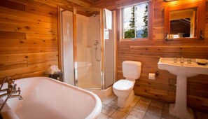 A beautifully crafted bathroom with natural wood accents provides a tranquil setting to refresh and unwind.